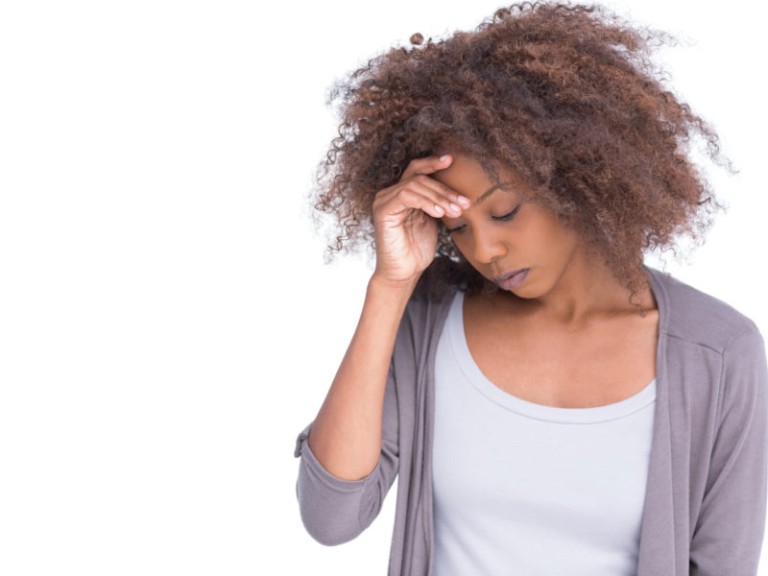 Sad woman holding her forehead with her hand on white background