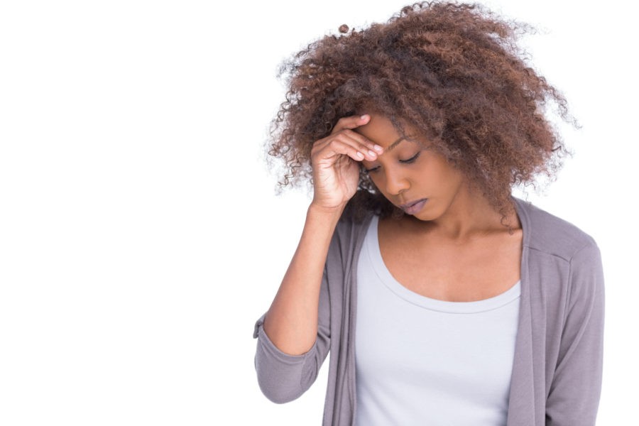 Sad woman holding her forehead with her hand on white background